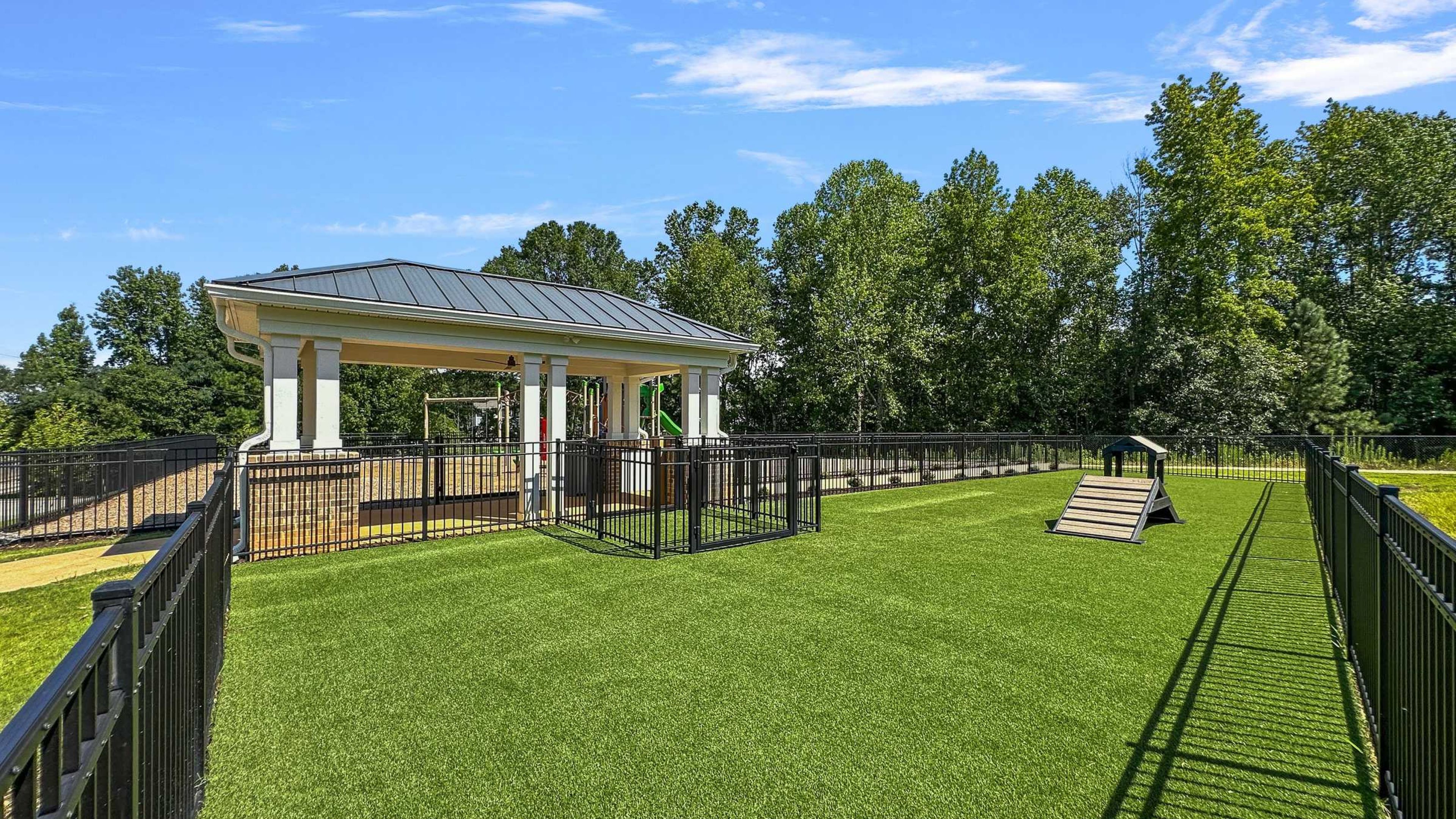 Hawthorne Palmetto apartments community exterior with large green lawn and dog park area